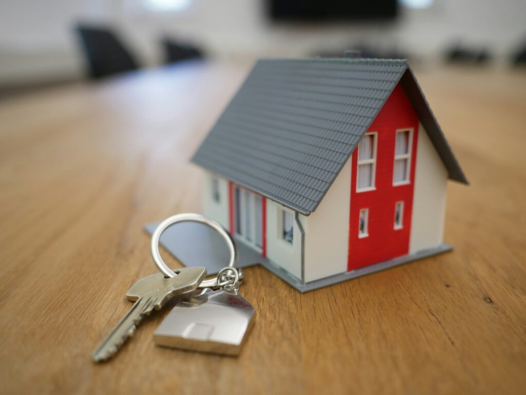 Small toy house sitting on the table next to a set of keys | Save time as a landlord | Bowen Property Management